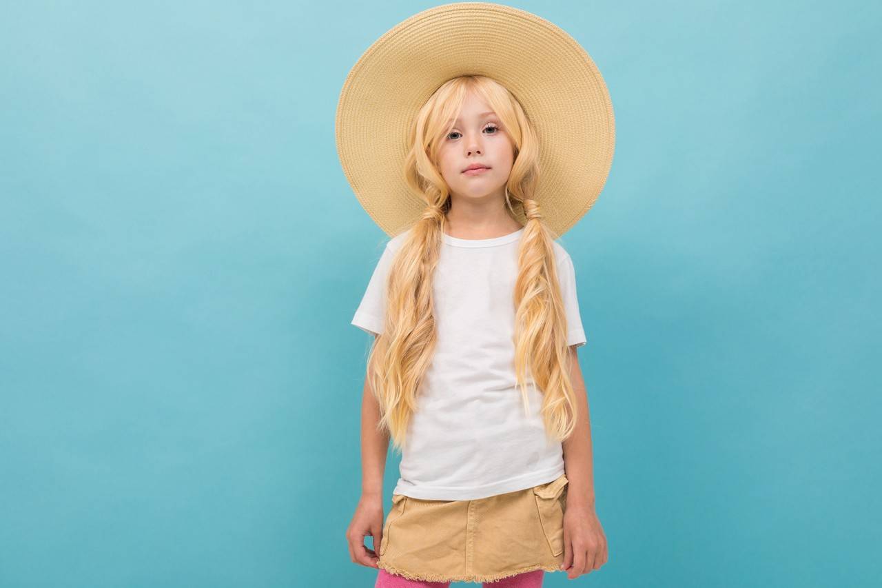 Criança com cabelo amarrado e chapeu de festa junina