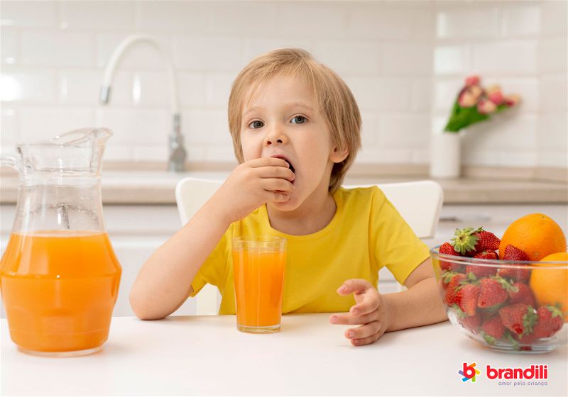 criança bebendo suco de laranja