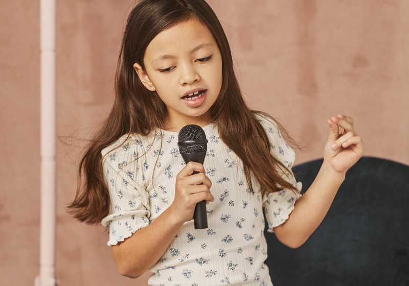 menina cantando com microfone 