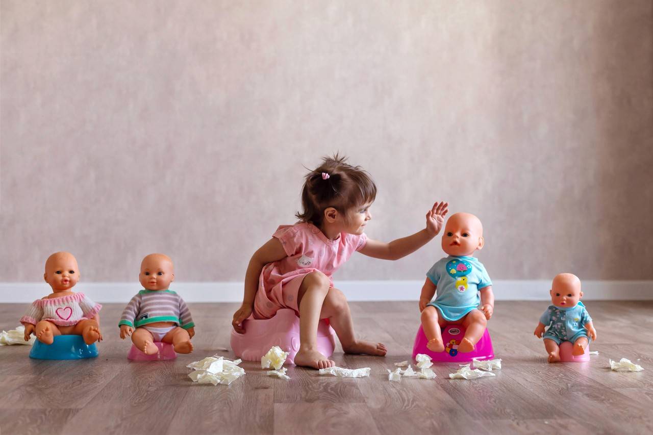 menina de dois anos aprendendo a usar o penico