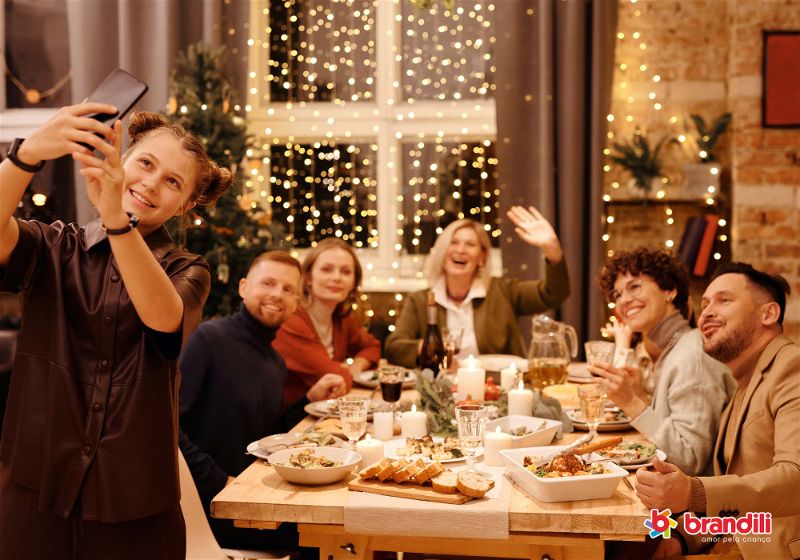 pessoas felizes reunidas em volta da mesa decorada em tema natalino