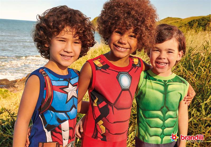 crianças na praia vestindo  camisetas de super herói