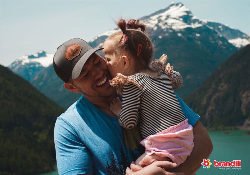 Pai segurando filha bebê numa viagem às montanhas