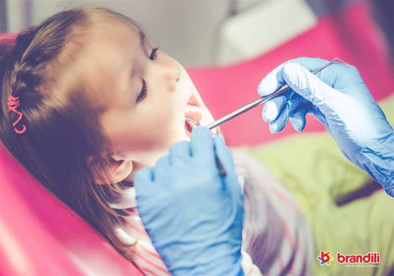 criança tratando do dente com dentista 