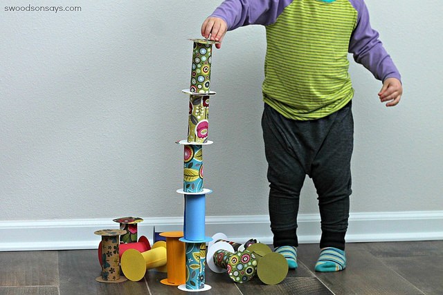 Criança empilhando tubos decorativos