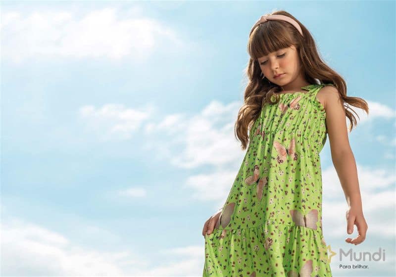 Menina usando um vestido verde com estampa de borboletas
