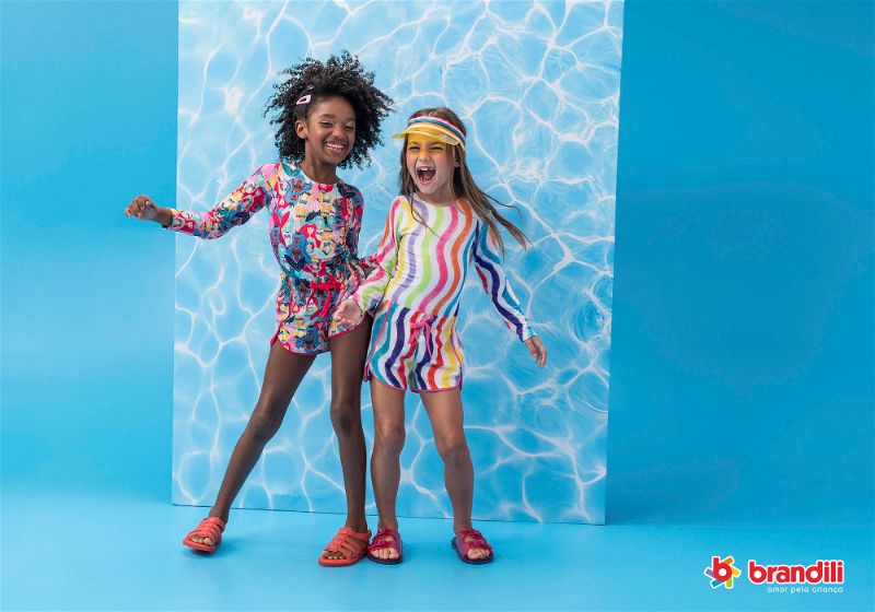 duas meninas sorrindo com roupa de praia estampada 