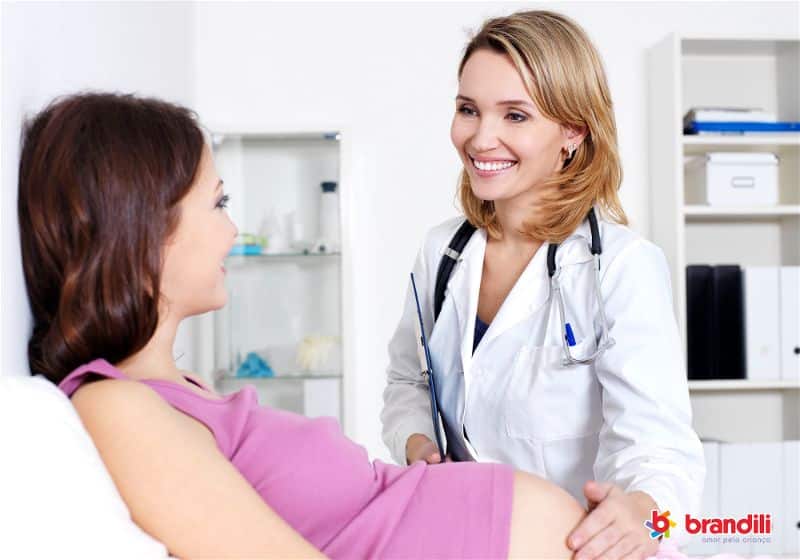 mulher grávida sendo examinada por médica 