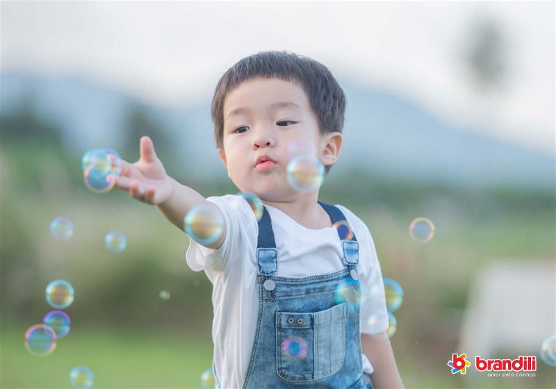 criança brincando com bolha de sabão 