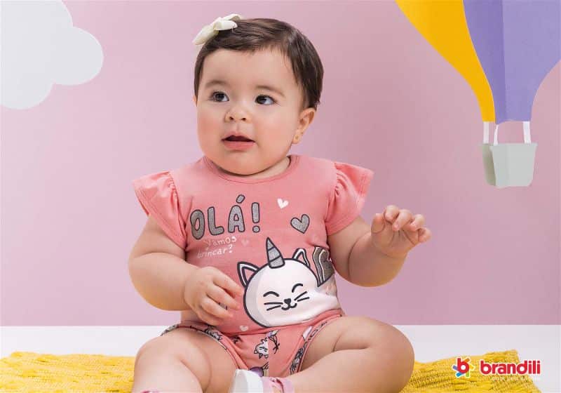 bebê menina sentada no tapete com roupa rosa