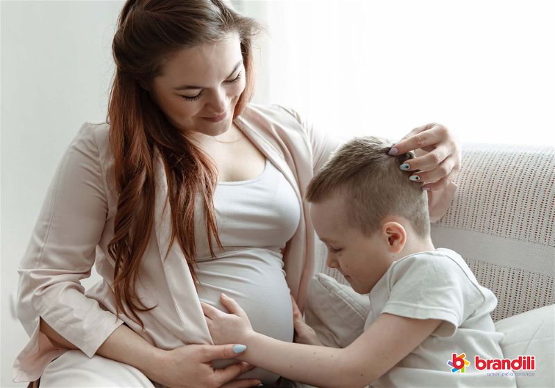 mulher grávida com o filho acariciando a barriga