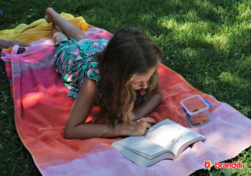 menina lendo sobre a grama