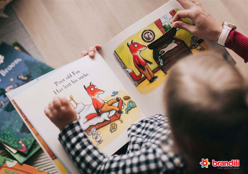 criança lendo livro sobre raposas