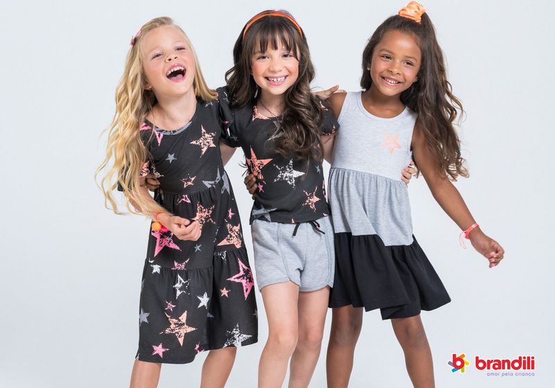 Três meninas posam com vestidos e conjuntos de malha da Brandili