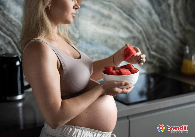 Mulher grávida comendo melancia