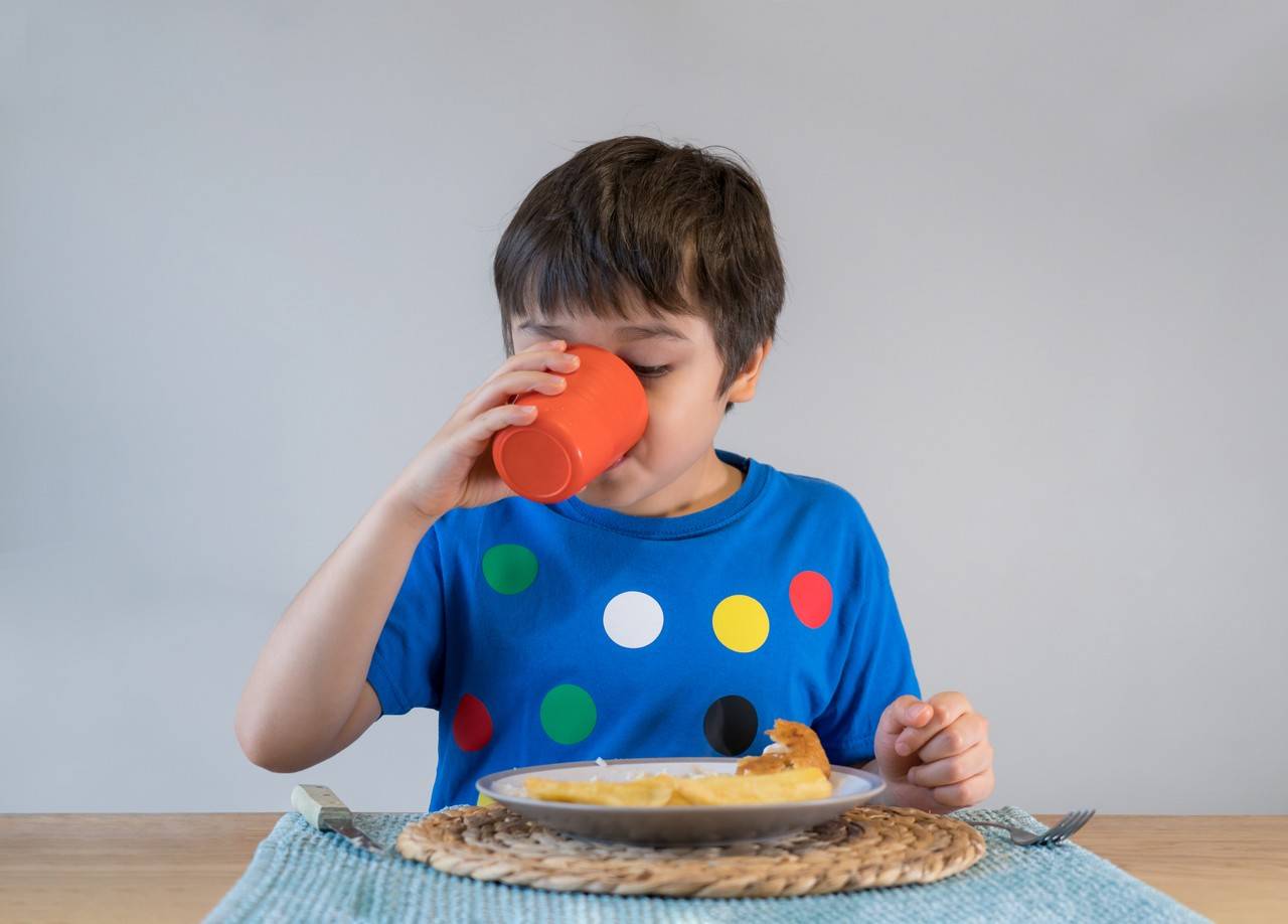 menino se alimentando de forma saudável na mesa