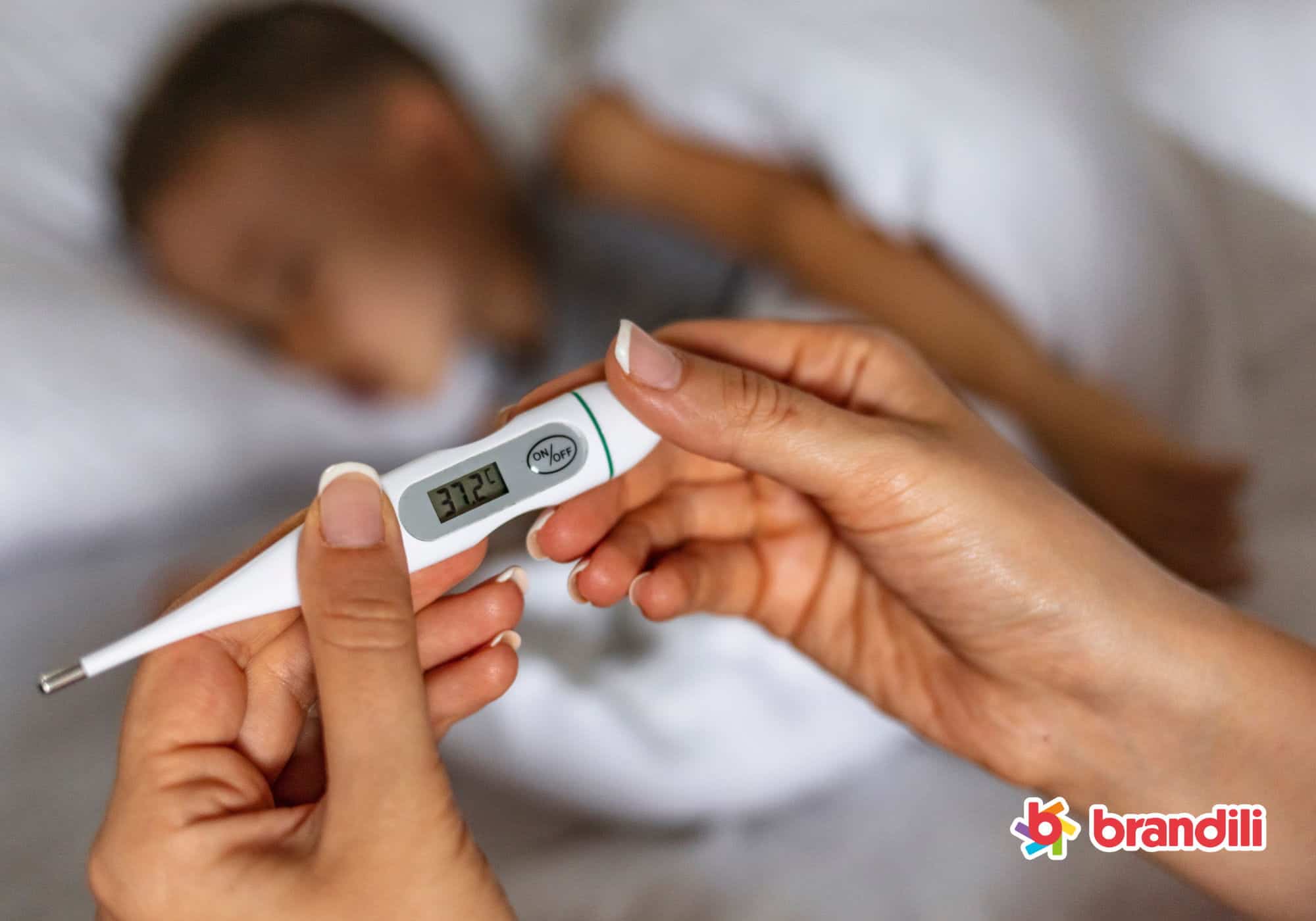 Mãe conferindo termômetro com a temperatura alta de seu filho