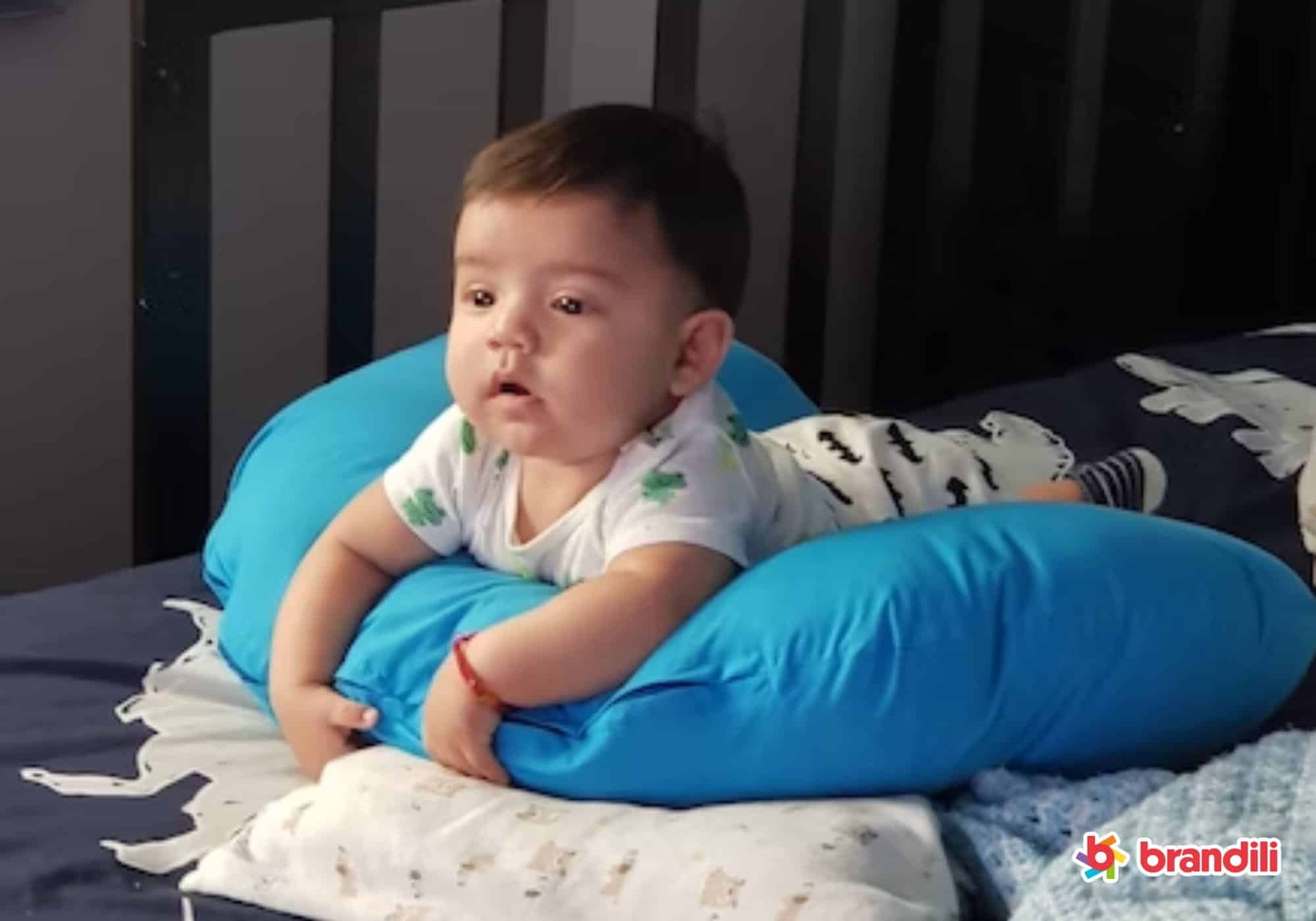 bebê deitado em almofada azul de massagem