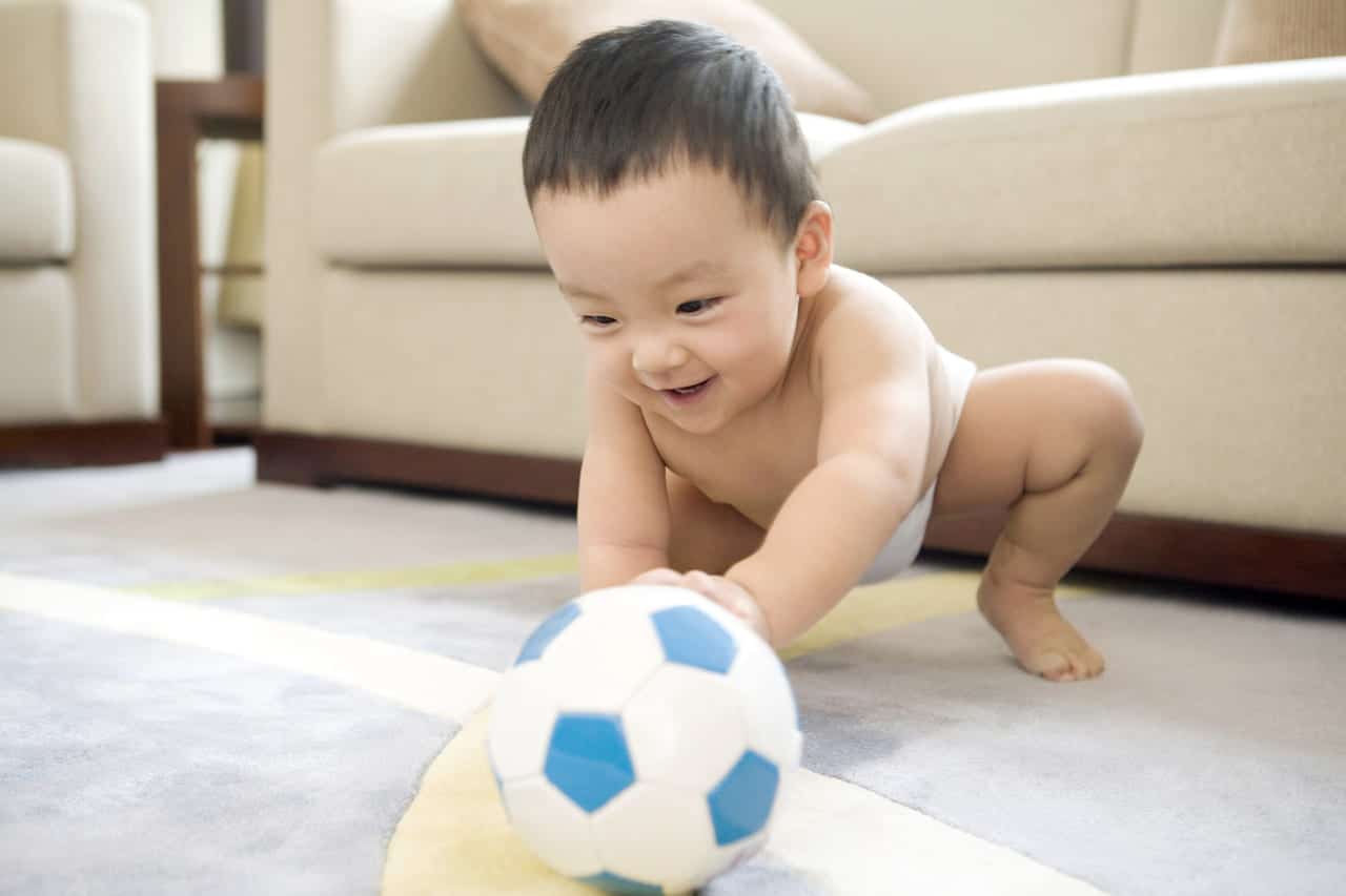 bebê brincando com uma bola de futebol 
