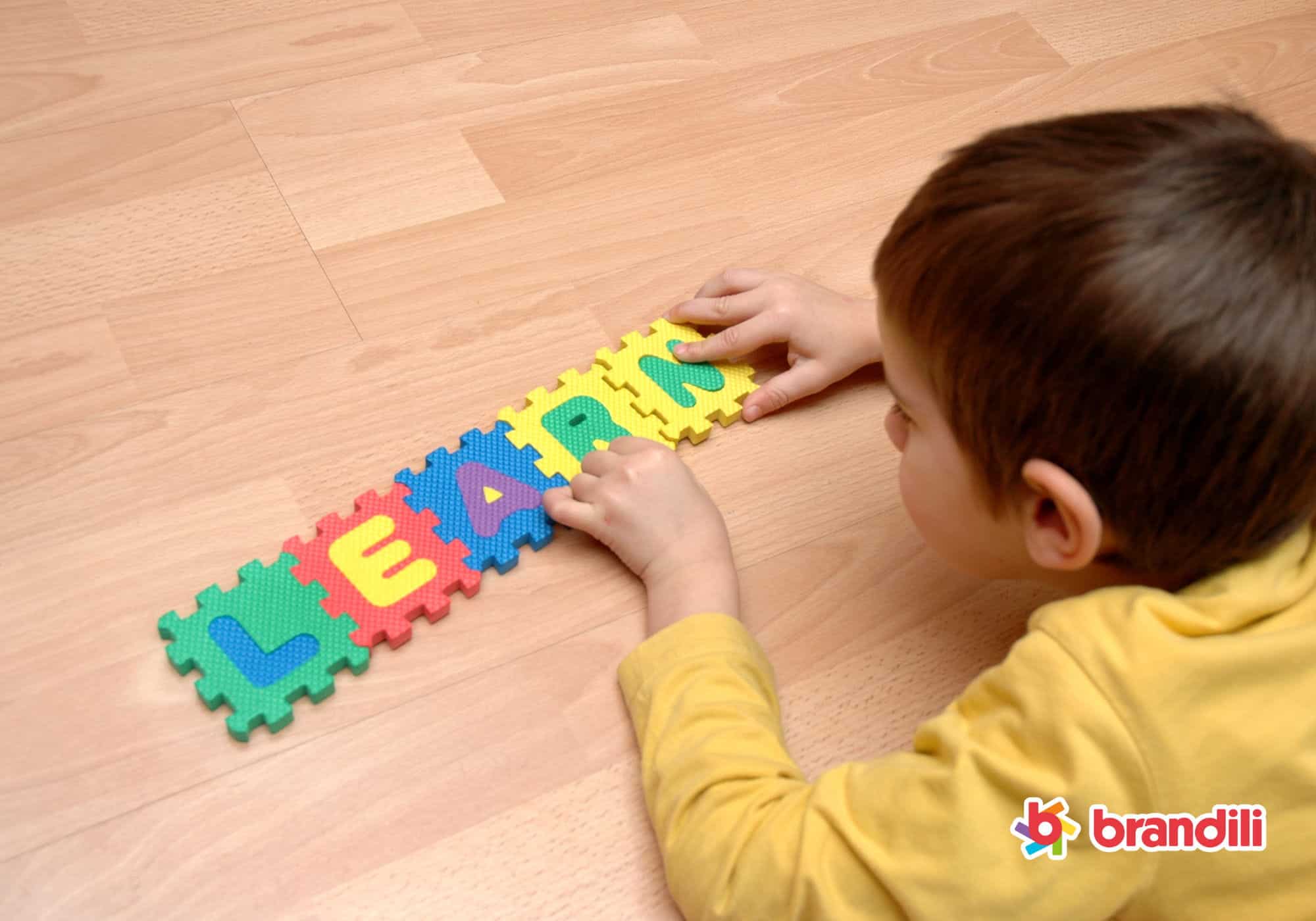 criança brincando com blocos que formam a palavra "LEARN"