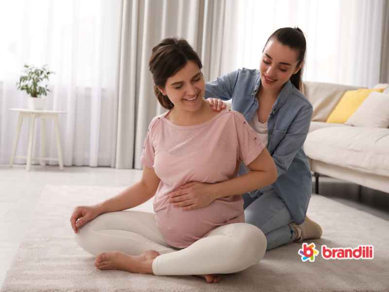 doula auxiliando uma mãe grávida em um exercício