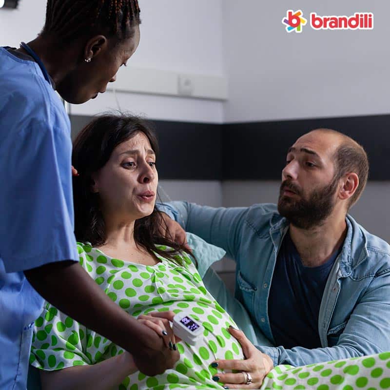 mulher gravida com dor recebendo assistencia medica com marido