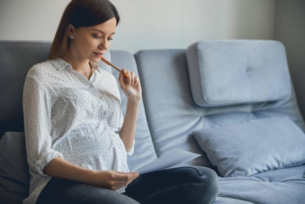 mulher grávida pensativa analisa com quantas semanas o bebe mexe