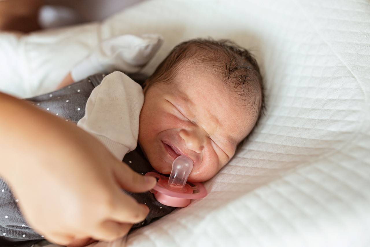 bebê com cólica deitado na cama