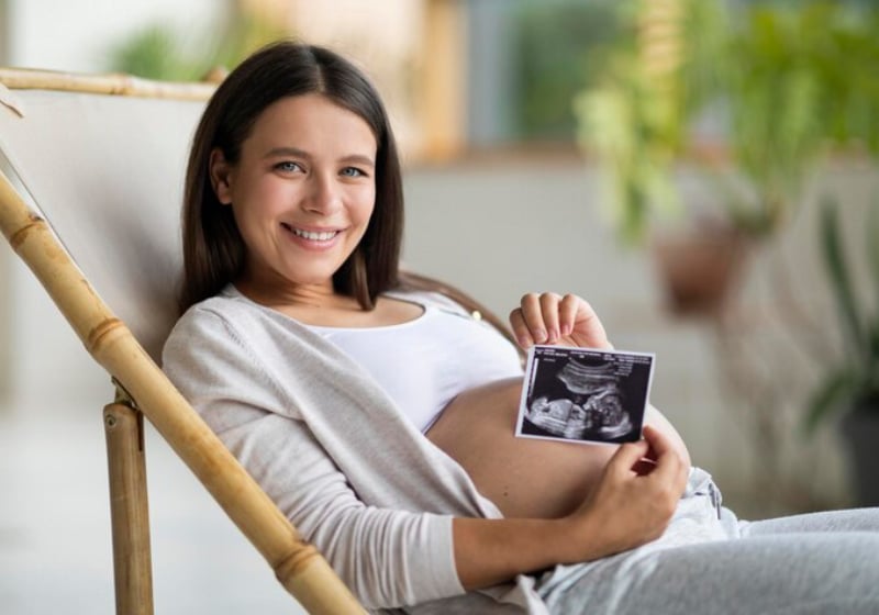 Mulher grávida segurando imagem do ultrassom