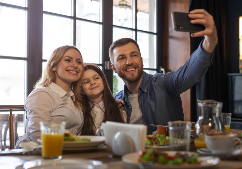 família tirando selfie em restaurante 