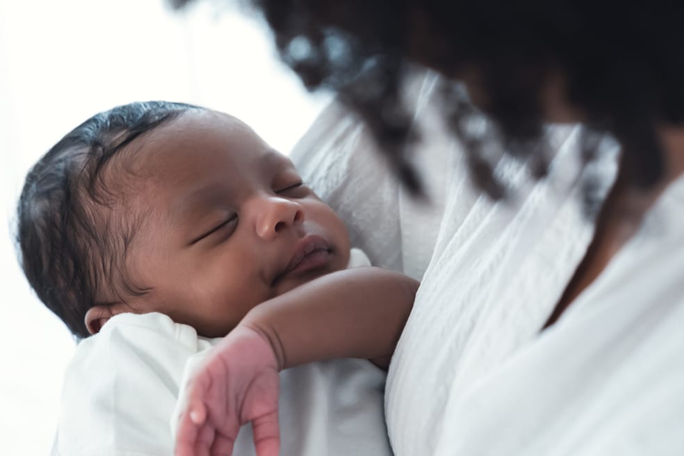 mulher, negra, segurando um recém nascido no colo