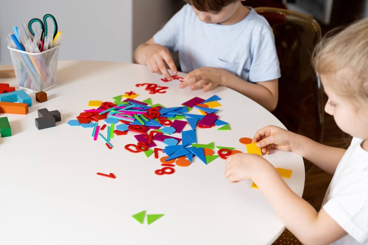 Duas crianças brincando com peças coloridas