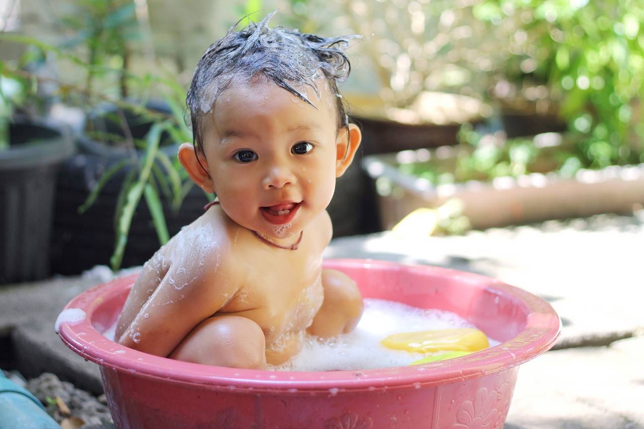 bebê tomando banho de banheira ao ar livre