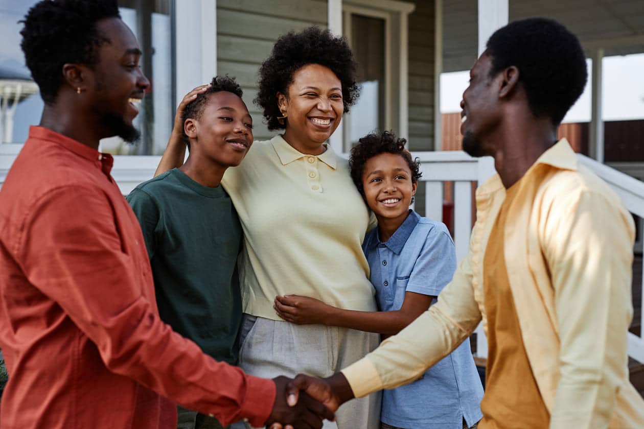 família de pessoas negras se reunindo em frente de casa 