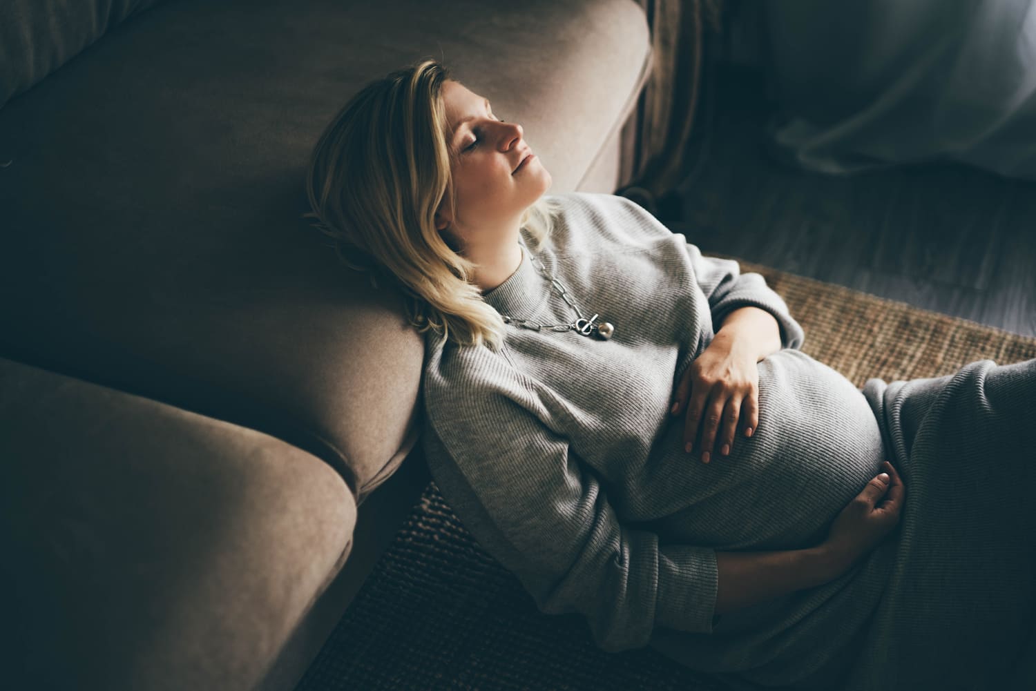 mulher grávida recostada no sofá 