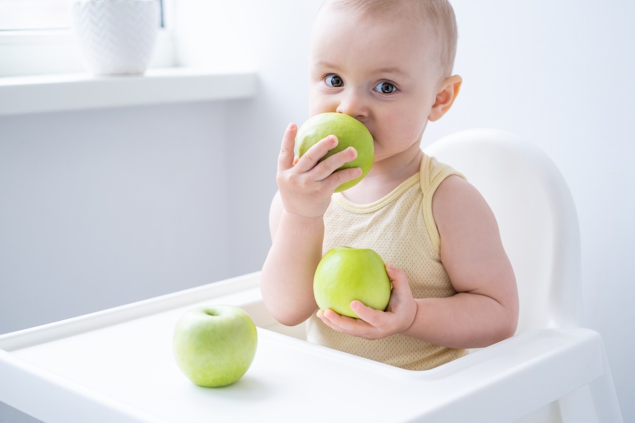 bebê comendo maçã verde