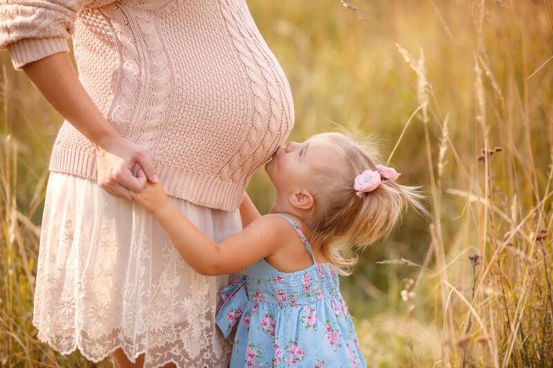 menina beija a barria da mãe grávida