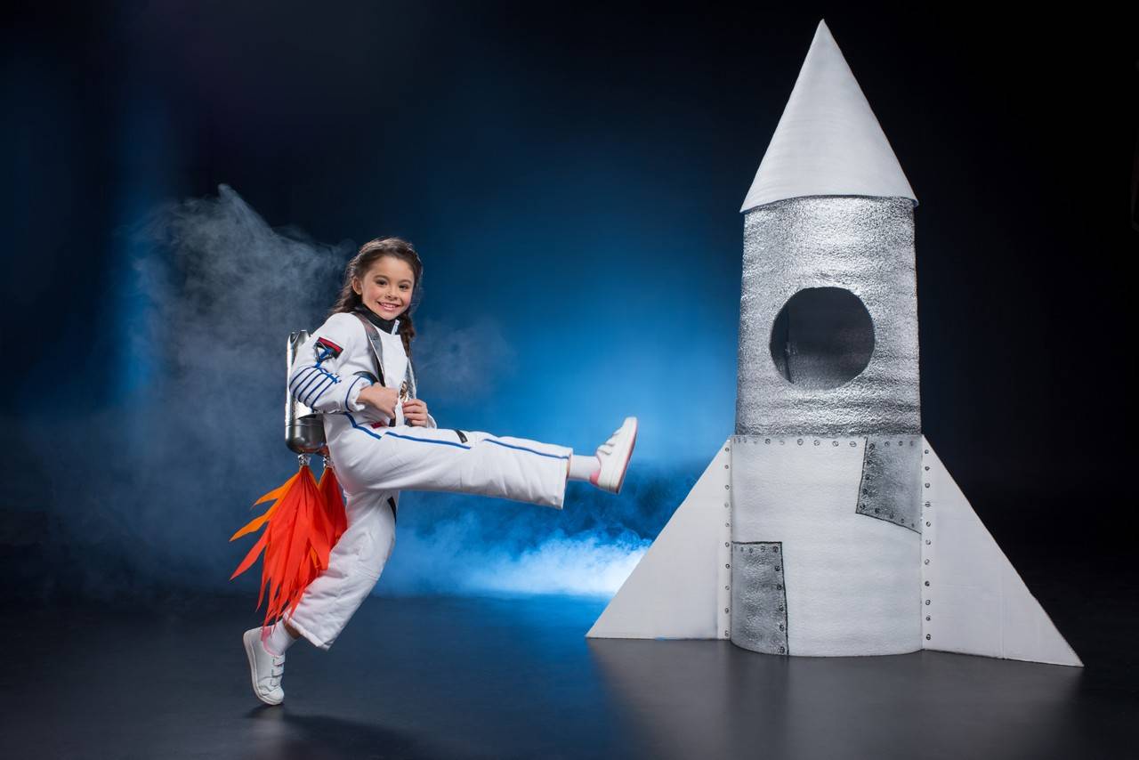 menina feliz fantasiada de astronauta