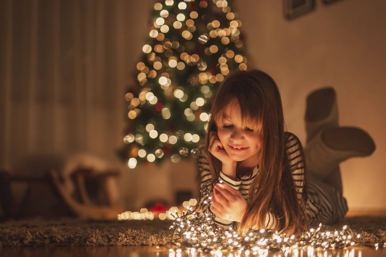  menina brincando com luzes de natal