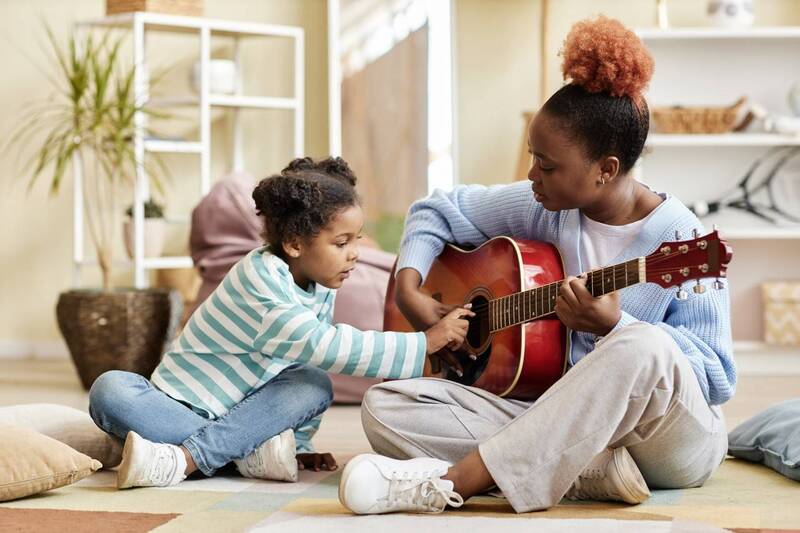 mãe e filha tocam violão juntas