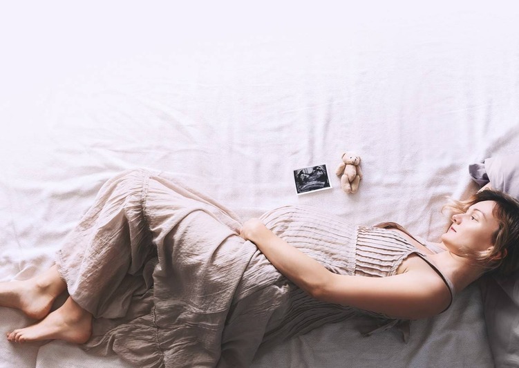 grávida deitada de lado enquanto observa um ultrassom