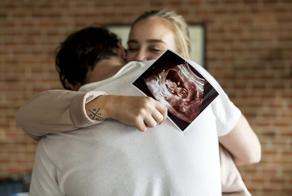 casal branco com ultrassom de bebê