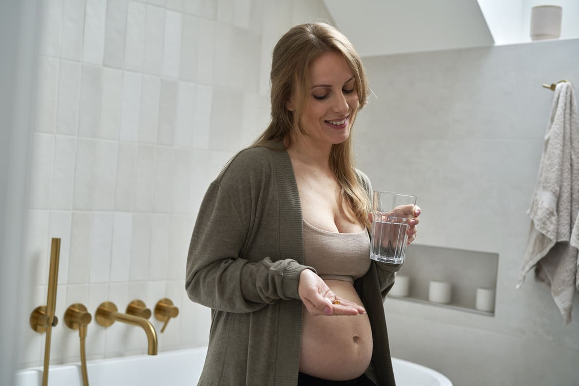 mulher com 11 semanas de gravidez tomando os remédios necessários para cuidar da saúde do bebê