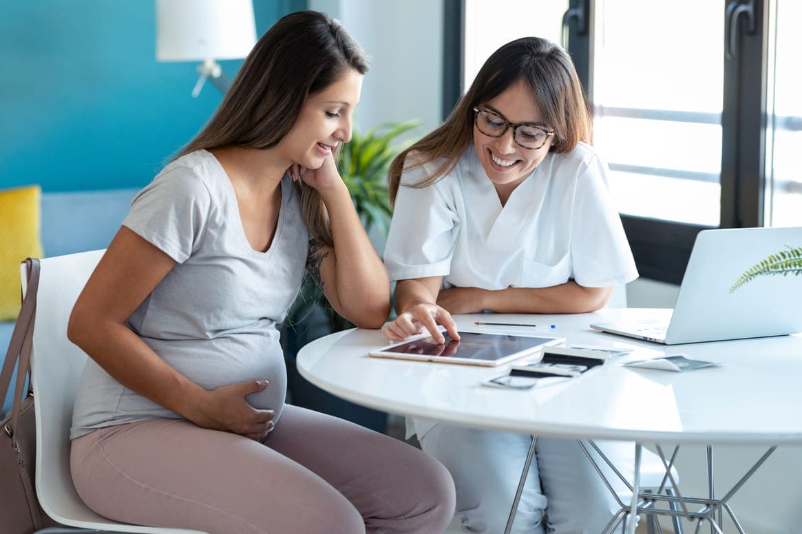 grávida de nove semanas sendo consultada pela ginecologista