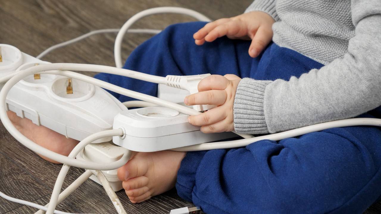bebê brincando com cabos de estensão