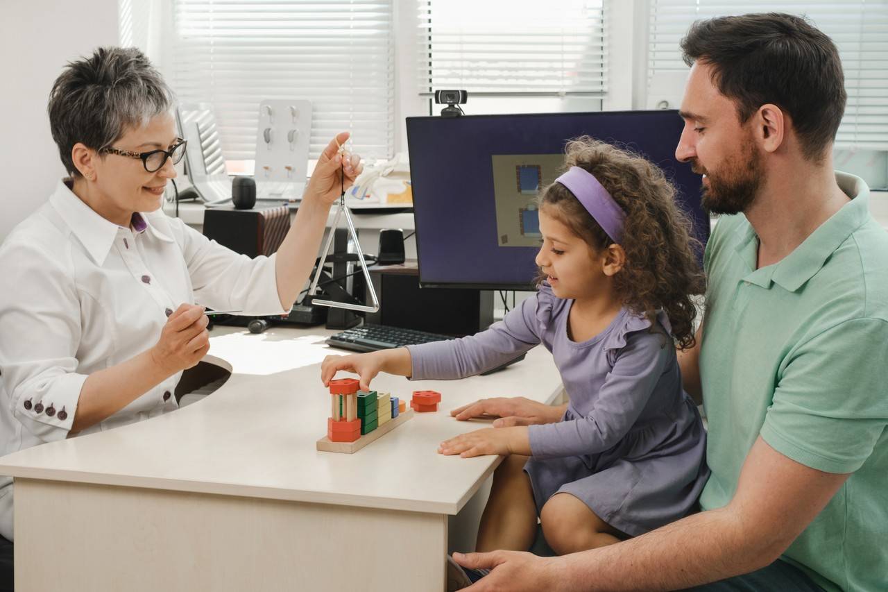 pai com a filha autista em um consultório de uma médica