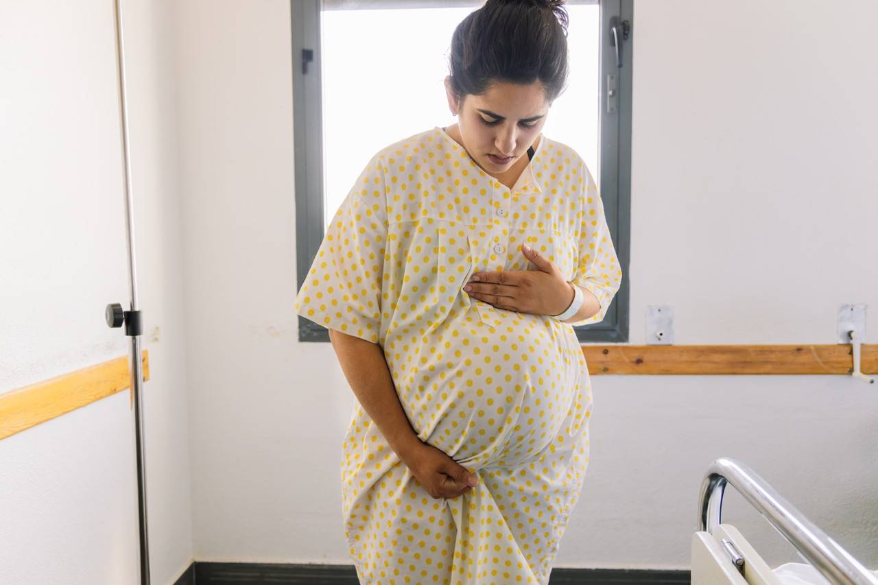 mulher grávida com vestido de parto se preparando em um hospital