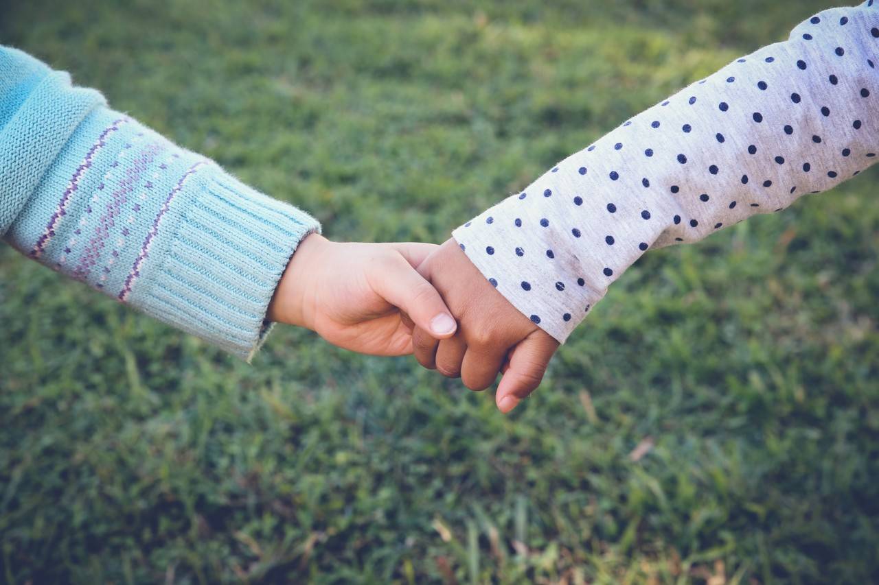 duas meninas pequenas com as mãos dadas