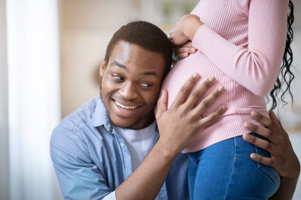 pai com ouvido na barriga de gestante