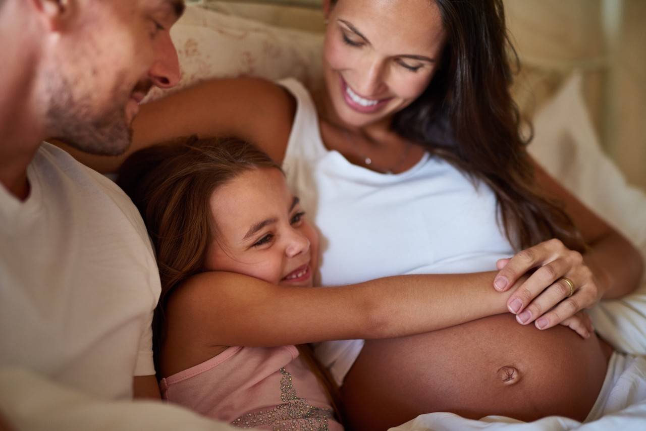 menina pequena abraçando a barriga da mãe gravida